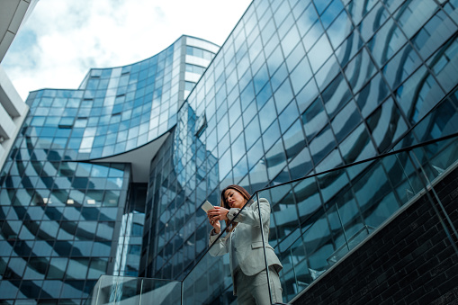 Young businesswoman in front of her workspace using cellphone