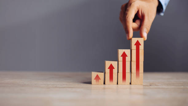 istock businessman hand  arranging wood block stacking as step stair with arrow up.concept for business growth success process. 1298103284