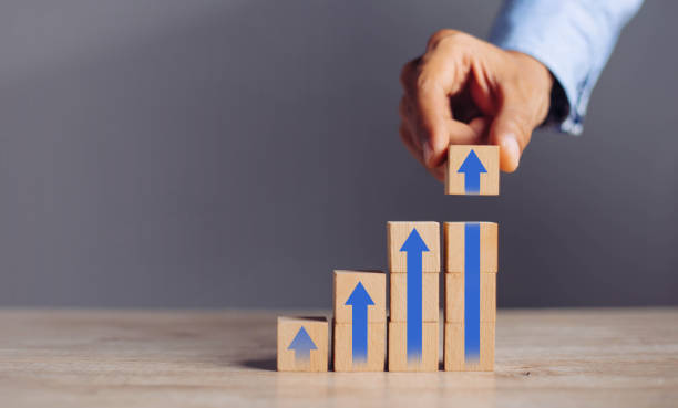 istock businessman hand  arranging wood block stacking as step stair with arrow up.concept for business growth success process. 1298103291