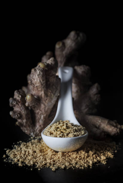 istock Ginger root and ginger powder on black background, closeup. 1298104131