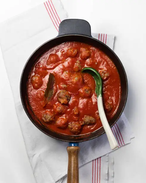 Cast iron pan with meatballs tomato sauce