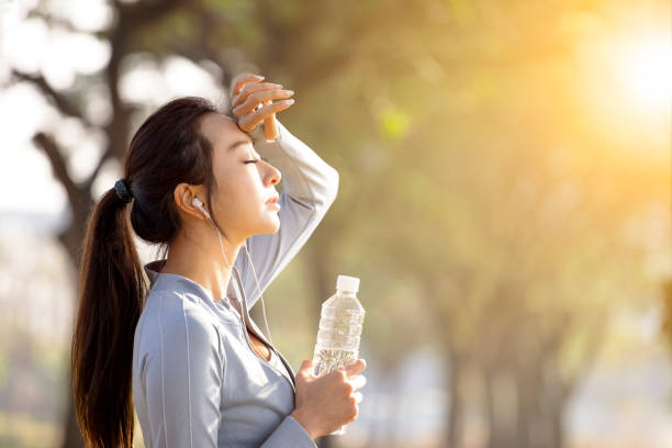 istock young woman drinking water after jogging 1298109327