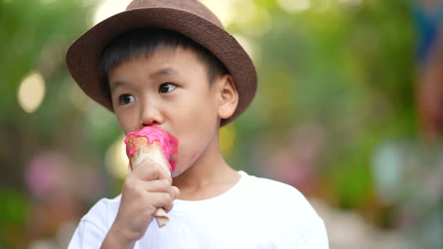 Asian boy lick melting ice cream and smiling. Concept of Happiness and summer
