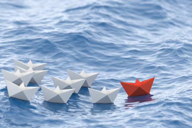 Leadership concept, red leader boat leading whites stock photo