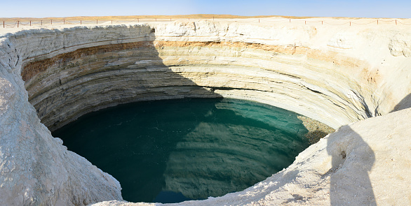 Karakum Desert north of Darvaza; Dashoguz Province; Turkmenistan: Turquoise crater - a water filled sinkhole in a natural gas field, the result of a collapsed cavern became a lagoon. Turkmenistan holds the world's 4th largest natural gas reserves.