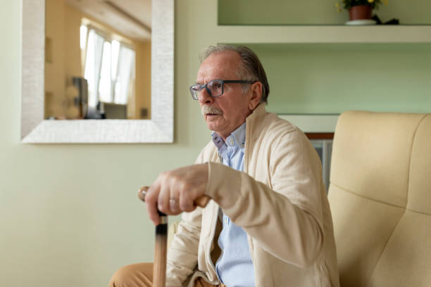 istock Lonely Senior Man is Sitting on Sofa at Home and Looking Sad. 1298114928