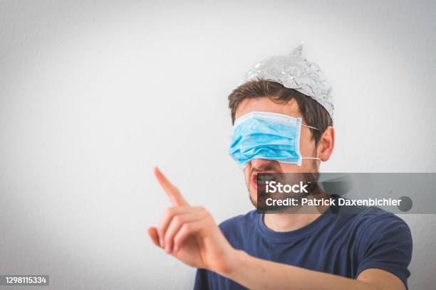 Conspiracy Theory Concept Young Angry Man Wearing Aluminum Hat And Face Mask Over The Eyes Is Gesturing Angry Stock Photo - Download Image Now
