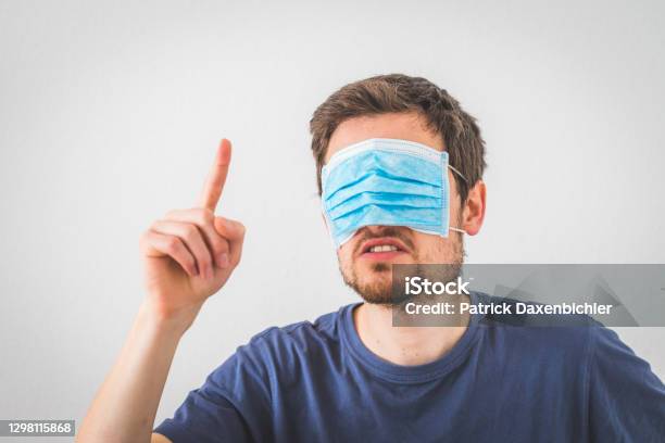 Conspiracy Theory Concept Young Angry Man Is Wearing Face Mask Over The Eyes Gesturing Angry Stock Photo - Download Image Now