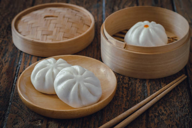 istock Steamed pork buns on wooden plate, Chinese dim sum 1298120337