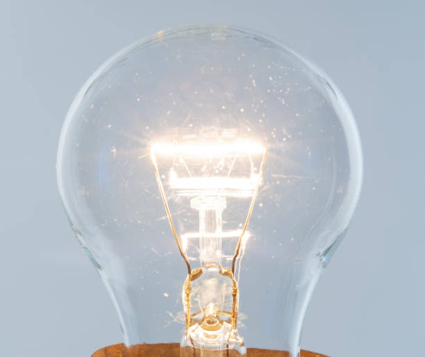 istock Glowing incandescent lamp.Gray background 1298121453