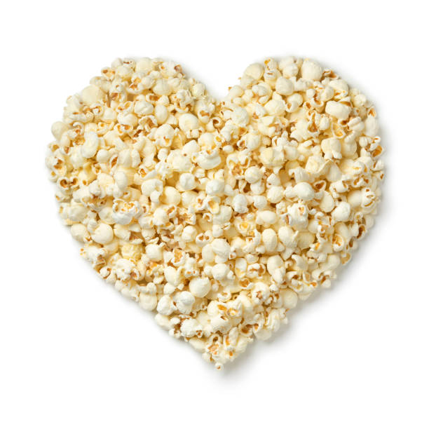 Salted popcorn in heart shape isolated on white background