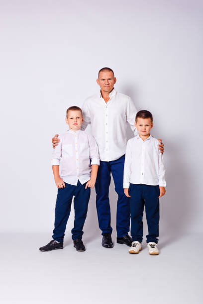 istock man and two boys in white shirts on white background 1298121630
