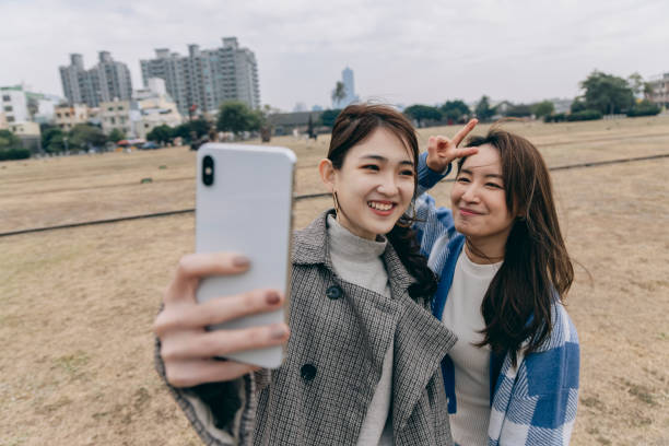 istock Two Asian women taking selfie in the park 1298124742
