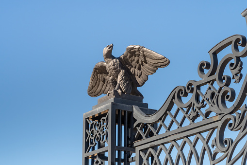 Haifa, Israel, January 22, 2021 : Decorative statue of a metal eagle with outstretched wings on the decorative metal entrance gate on the upper terrace of the Bahai Garden in Haifa city, Israel