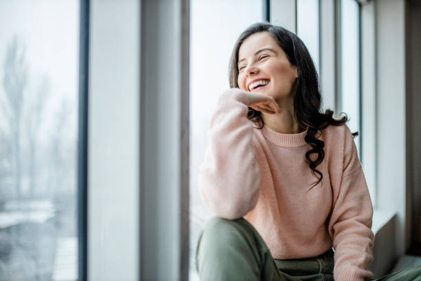 istock Beautiful young smiling woman looking outside window 1298126864