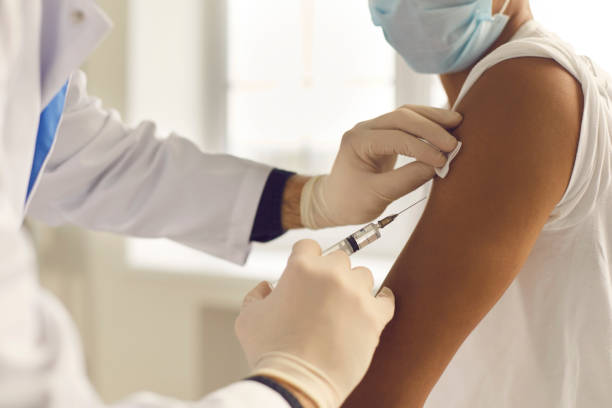 closeup of doctor in medical gloves holding syringe and giving vaccine to patient - syringe injecting vaccination cold and flu imagens e fotografias de stock