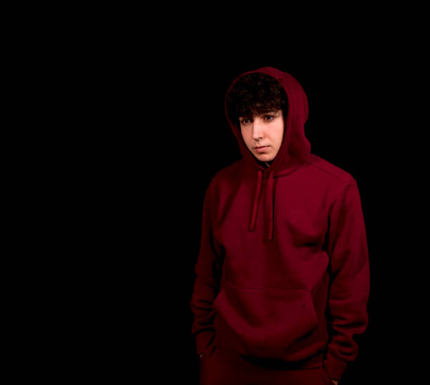 istock Attractive young man with curly hair posing on black background 1298132995