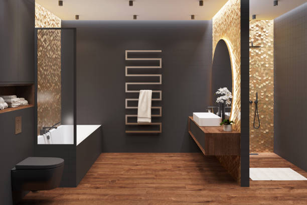 interior de un baño negro con suelo de madera con ducha, lavabo, un gran espejo sobre una pared de mosaico dorado, una toalla, un toallero calefactado, un baño con tabique, un inodoro. - water plant fotografías e imágenes de stock