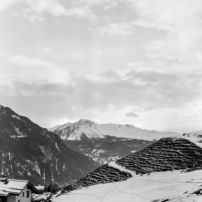 View of the Alpine mountain range in winter from the top of the village of Alvaneu in Switzerland, shot with black and white analogue film technique
