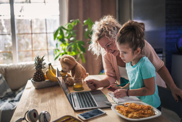 little child girl with grandmother using laptop at home - eating senior adult color image spaghetti imagens e fotografias de stock