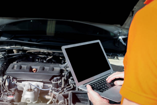 istock Auto mechanic hand holding laptop, working with engine in garage, car service technician repairing customer car at automobile service, vehicle repair service shop 1298136887