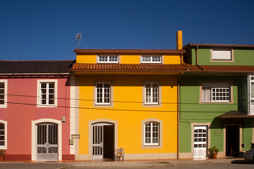 Front view of multicolored houses in a row, clear blue sky background. A Coruña province, Galicia ,Spain.