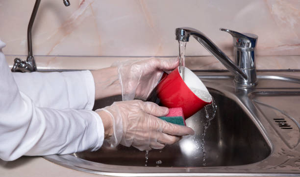 istock Human washes red cup.  Close up of hand with sponge. 1298137974