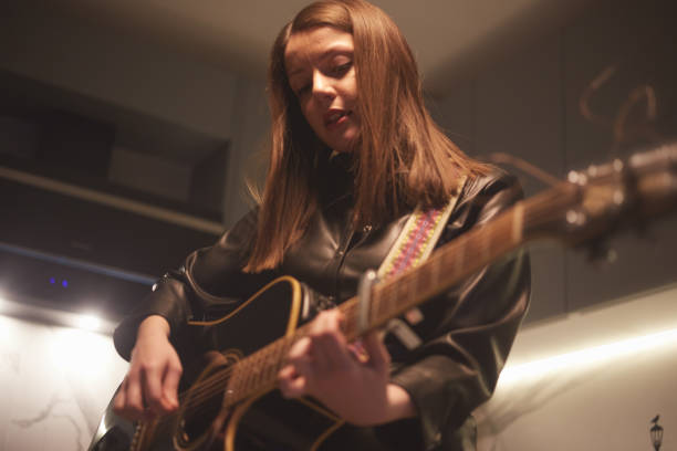 istock a woman is playing guitar in the kitchen 1298137989