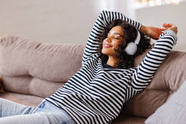 istock Ethnic female listening to music on sofa 1298138046