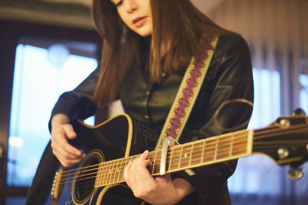 istock a woman is playing guitar in the kitchen 1298139106