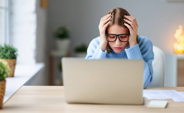 istock Tired female freelancer working at home 1298139299