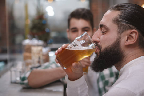 istock Male friends drinking beer at pub 1298139747