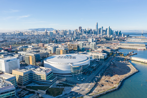 An aerial view of Mission Bay and new Mission Rock development with the San Francisco skyline in the background and Chase center in the foreground.