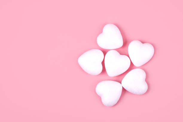 istock Some white hearts on a pink background 1298140866