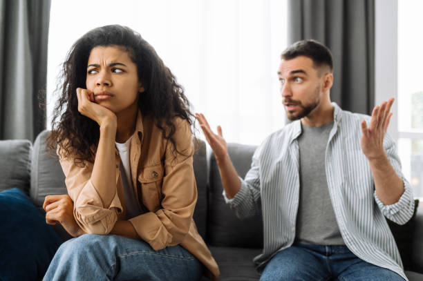 istock Married young couple emotional discuss about something, they having problem. African american woman and caucasian man disagree with each other have a misunderstanding, cant make decision, a quarrel between lovers 1298143173