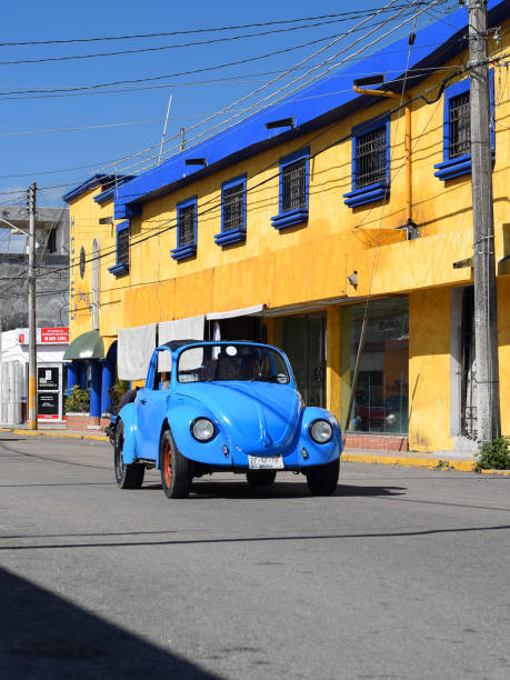 Classic Volkswagen Beetle on a street San Miguel de Cozumel, Mexico - 9th January, 2018: Classic blue Volkswagen Beetle driving on a street. This model was the most popular vehicle in the world. san miguel de cozumel stock pictures, royalty-free photos & images