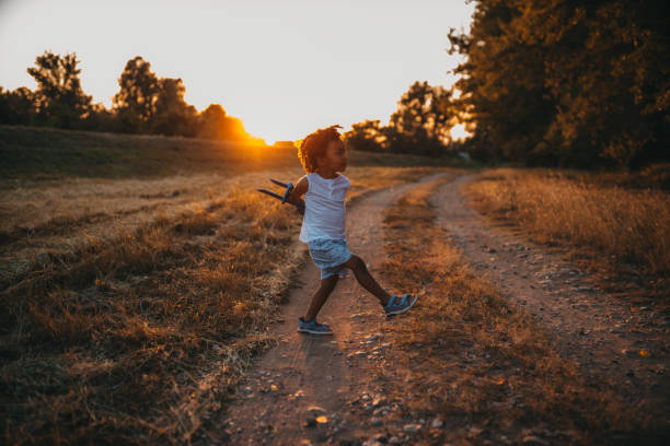istock Boy playing with airplane toy in field 1298151201