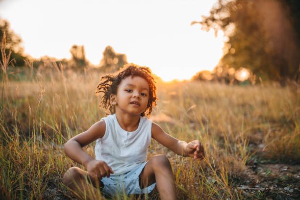 istock The little boy is sitting in the grass 1298151289