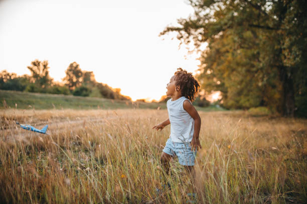 istock Young boy playing with toy airplane outside 1298151303