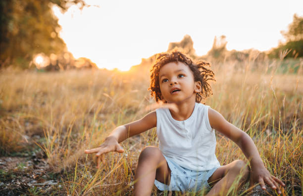 istock The little boy is sitting in the grass 1298151406
