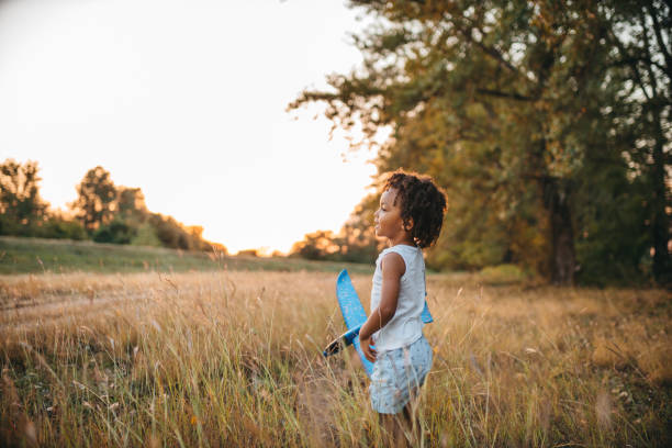 istock Young boy playing with toy airplane outside 1298151425