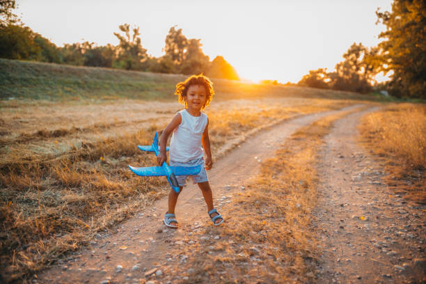 istock Boy playing with airplane toy in field 1298151482