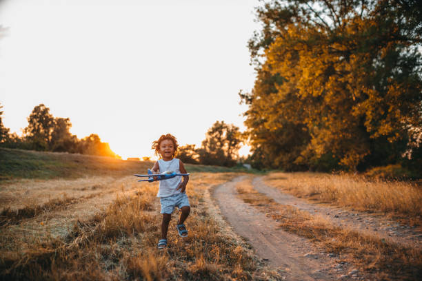 istock Boy playing with airplane toy in field 1298151496