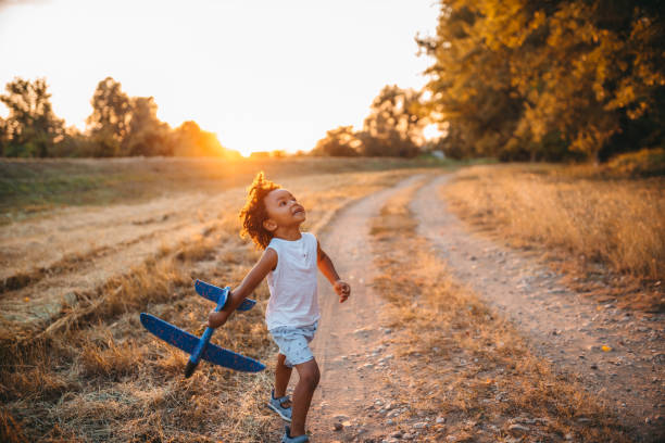 Boy playing with airplane toy in field