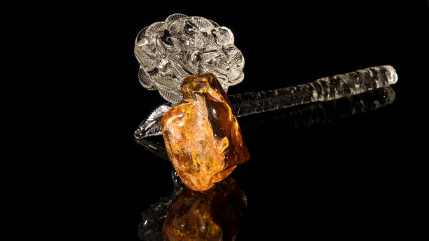 istock Large old sparkling orange Baltic amber stone on a black background. 1298152478
