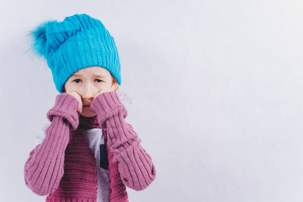 istock The child stands on a white background in winter clothes. 1298152909
