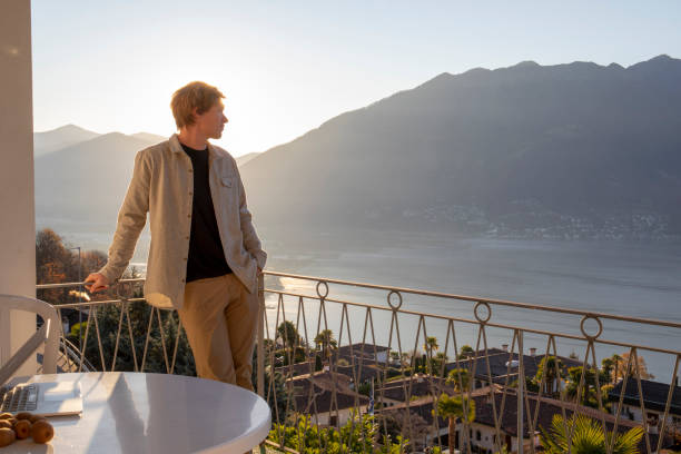 istock Young man works from home on balcony in the morning 1298153170