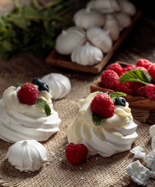 istock Dessert Pavlova and small meringues on a rustic background. 1298155684
