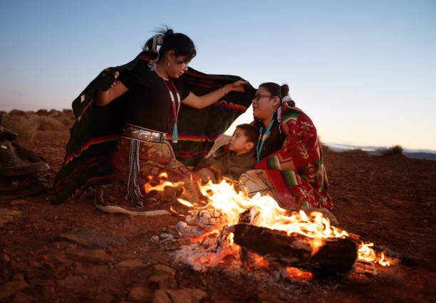 istock Navajo siblings warming up around campfire at sunset 1298157217
