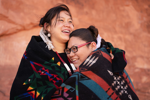 Cheerful navajo sisters hugging
